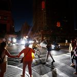 Pedestrians cross the street during the blackout ( Michael Owens/AP/Shutterstock)